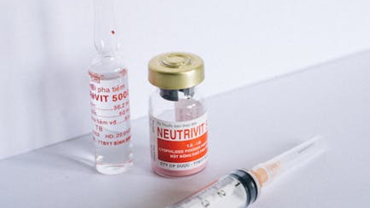 Close-up of a sterile syringe with a vial of peptide solution nearby, representing peptide injection sites.